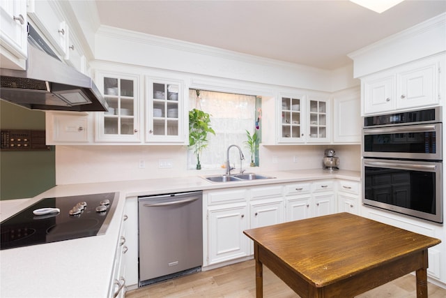kitchen featuring light countertops, under cabinet range hood, white cabinets, a sink, and appliances with stainless steel finishes