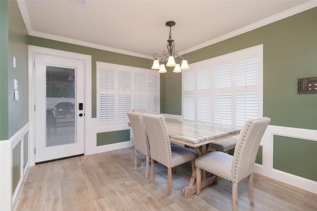 dining room featuring visible vents, ornamental molding, light wood finished floors, and a chandelier