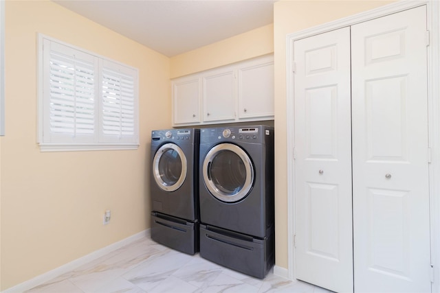 washroom with baseboards, cabinet space, independent washer and dryer, and marble finish floor