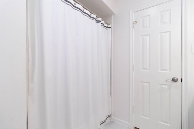 full bathroom featuring baseboards and a shower with shower curtain