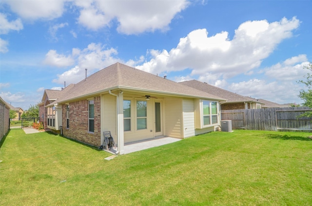 rear view of property with a yard, brick siding, and a fenced backyard