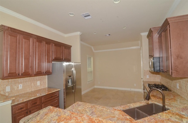 kitchen with visible vents, appliances with stainless steel finishes, light stone countertops, a sink, and baseboards