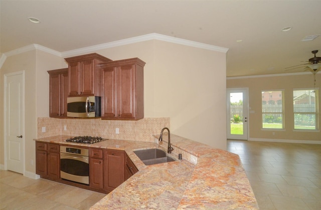 kitchen with open floor plan, ceiling fan, tasteful backsplash, a sink, and stainless steel appliances