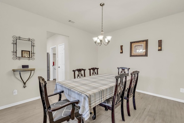 23134 Quiet Heron Ct, Katy, TX 77493 - dining room with light wood-style floors, a chandelier, and baseboards