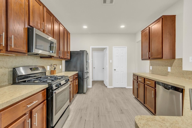 23134 Quiet Heron Ct, Katy, TX 77493 - kitchen with appliances with stainless steel finishes, light countertops, backsplash, light wood-style flooring, and recessed lighting