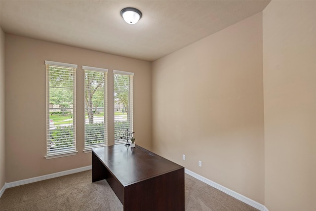 unfurnished office featuring baseboards and light colored carpet