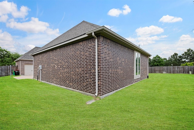 view of side of home with fence, a lawn, and brick siding