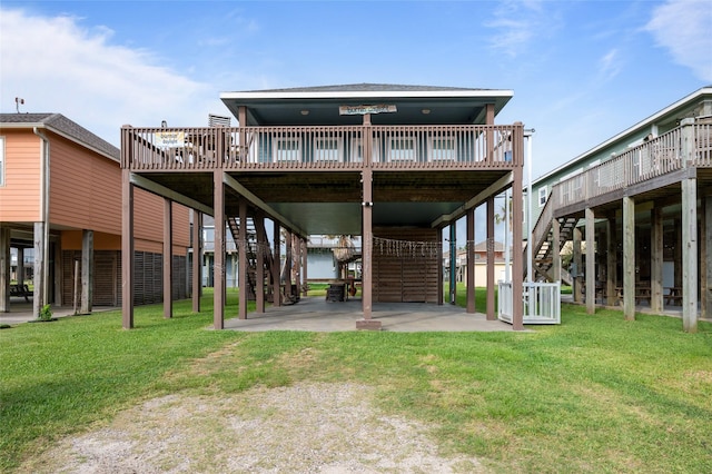 rear view of house featuring stairway, a deck, and a lawn
