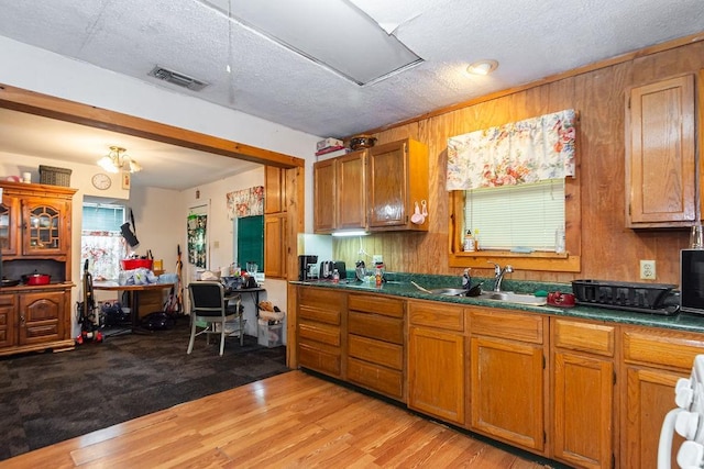 1817 Mcdaniel St, Houston, TX 77093 - kitchen featuring dark countertops, visible vents, brown cabinetry, and a sink