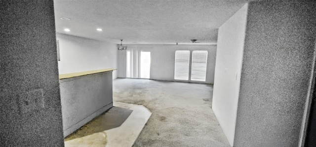 empty room with carpet flooring, recessed lighting, and a textured ceiling