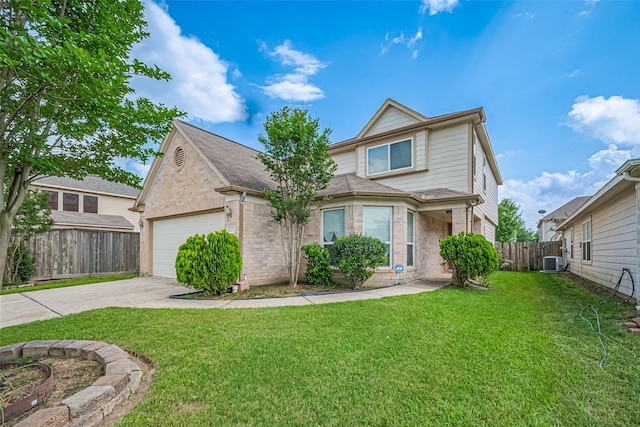 traditional-style house featuring concrete driveway, fence, and a front yard