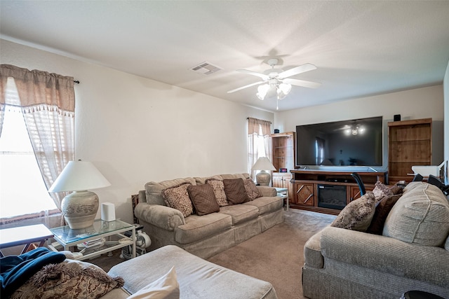 living room with visible vents, carpet floors, and ceiling fan