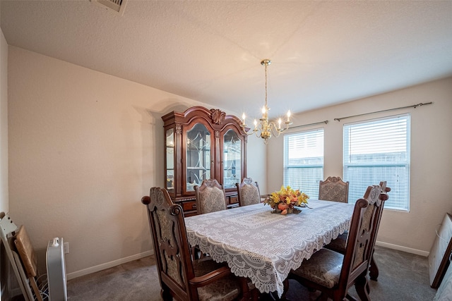 carpeted dining space featuring baseboards and an inviting chandelier