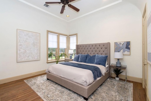 bedroom with a ceiling fan, baseboards, visible vents, and wood finished floors
