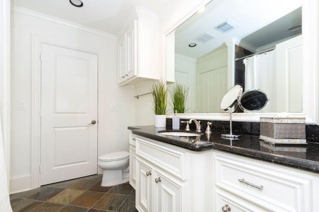 bathroom with vanity, ornamental molding, visible vents, toilet, and stone finish floor
