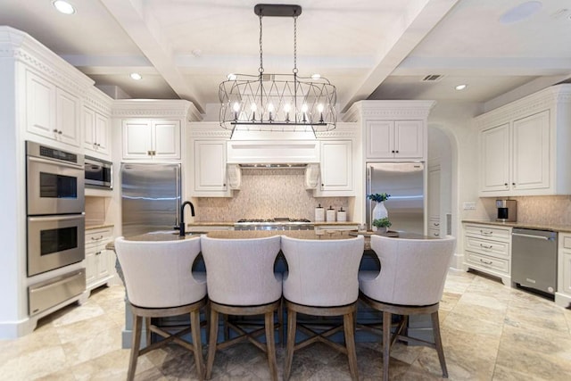 kitchen featuring a warming drawer, beamed ceiling, stainless steel appliances, and backsplash