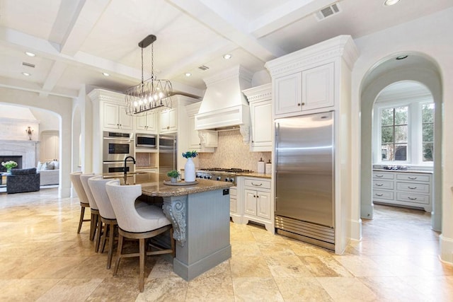 5262 Huckleberry Ln, Houston, TX 77056 - kitchen with built in appliances, arched walkways, coffered ceiling, premium range hood, and tasteful backsplash