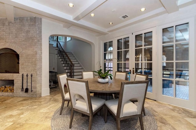 5262 Huckleberry Ln, Houston, TX 77056 - dining room featuring beamed ceiling, french doors, stairway, a brick fireplace, and arched walkways