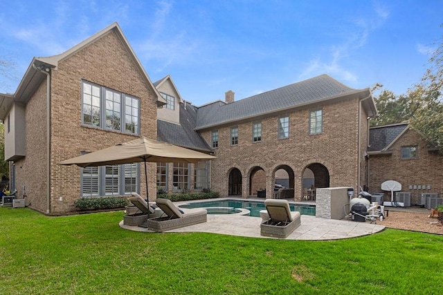 5262 Huckleberry Ln, Houston, TX 77056 - rear view of house with a patio area, brick siding, a yard, and a pool with connected hot tub