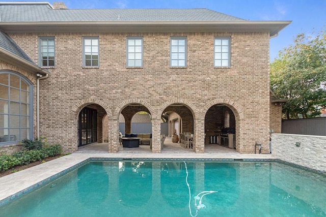 pool featuring an outdoor living space and a patio area