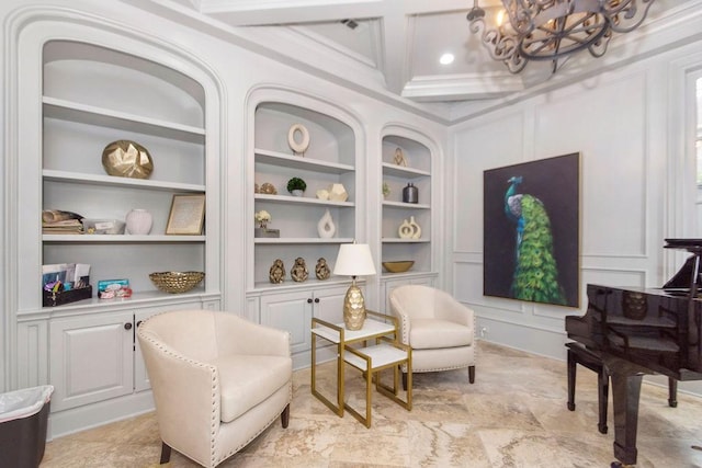 living area with coffered ceiling, an inviting chandelier, built in features, and a decorative wall