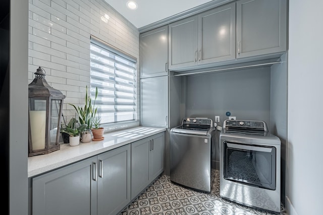 washroom with separate washer and dryer and cabinet space
