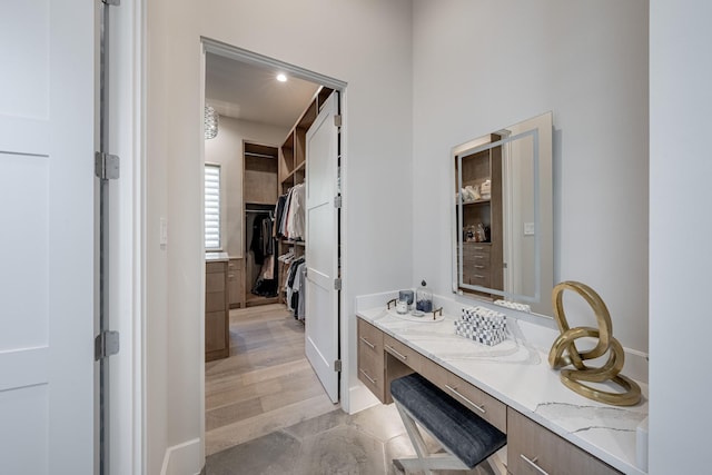 bathroom with vanity and a spacious closet
