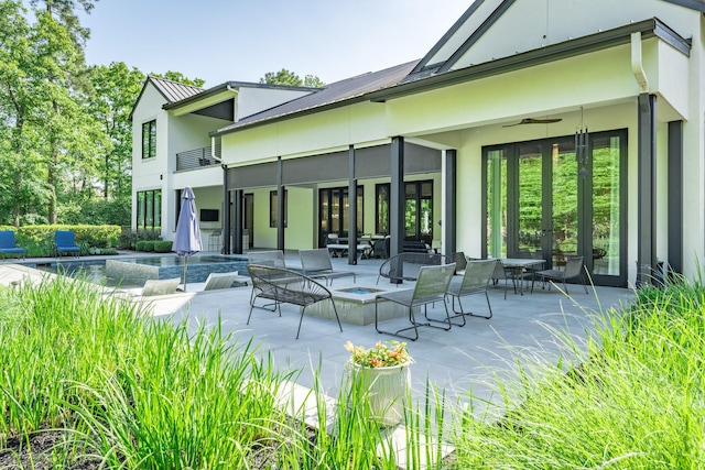 back of property featuring stucco siding, french doors, a fenced in pool, a ceiling fan, and a patio area