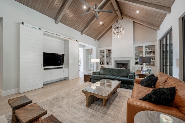 living area with a ceiling fan, a barn door, beam ceiling, high vaulted ceiling, and light wood-style flooring