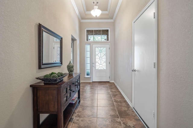 doorway to outside with crown molding, a textured wall, and a tray ceiling