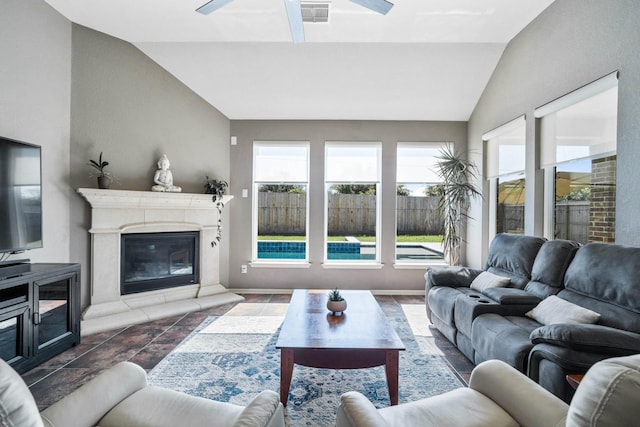 living area featuring a high end fireplace, a ceiling fan, vaulted ceiling, and visible vents