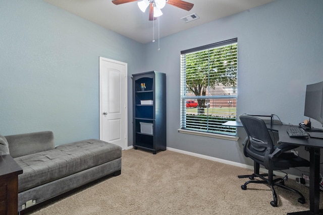 carpeted home office with ceiling fan, visible vents, and baseboards