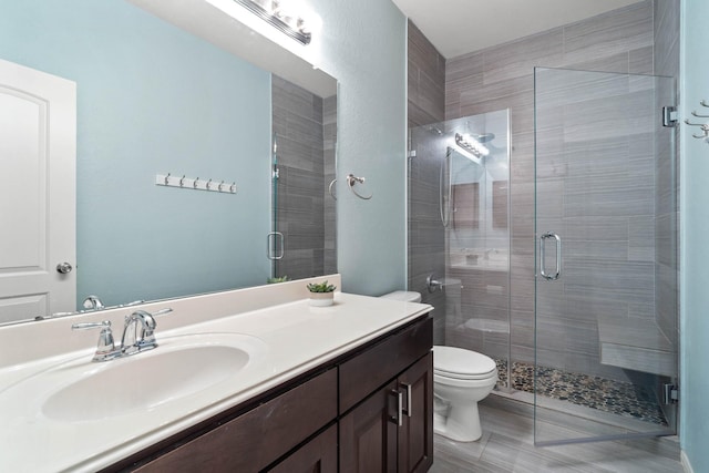 bathroom with vanity, a stall shower, and toilet
