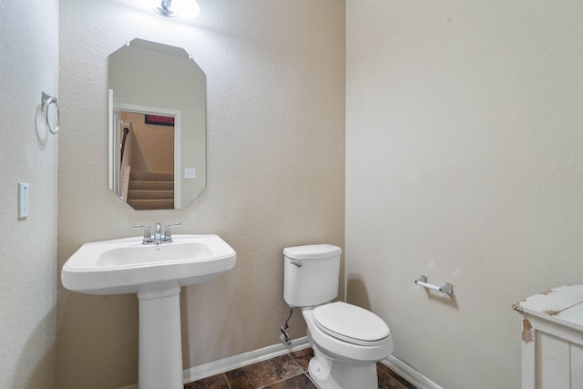 bathroom featuring a sink, baseboards, and toilet