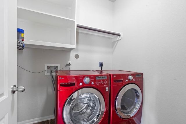 clothes washing area with washing machine and clothes dryer, laundry area, and baseboards