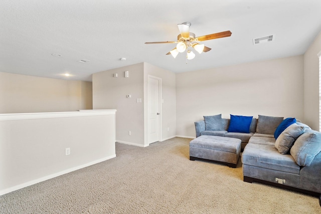 living area featuring carpet flooring, ceiling fan, visible vents, and baseboards