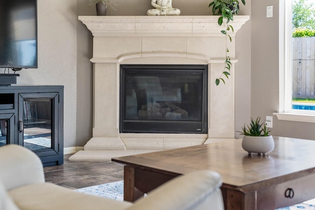 living area featuring baseboards, a high end fireplace, and plenty of natural light