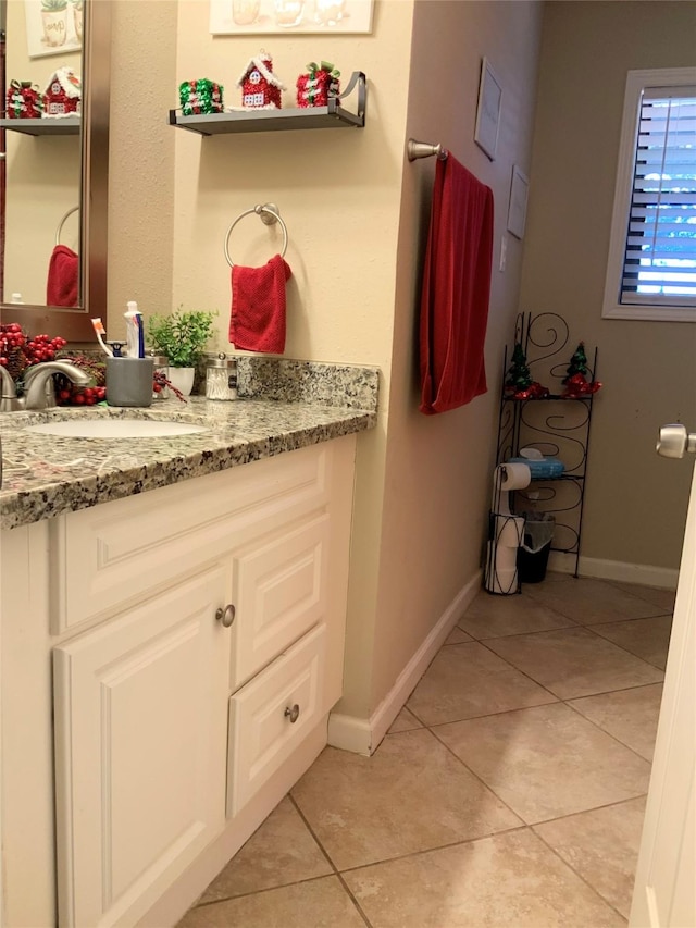 bathroom with baseboards, tile patterned flooring, and vanity