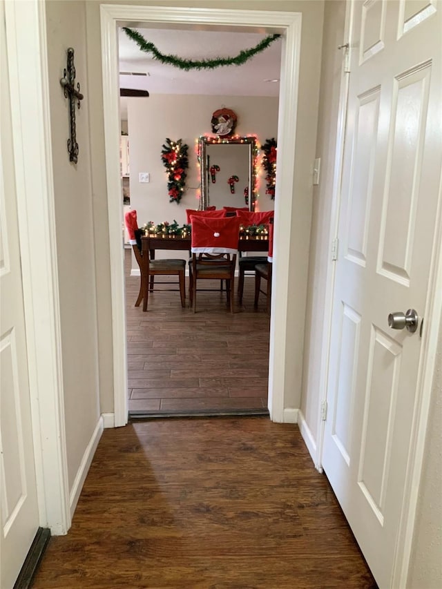 hallway with baseboards and dark wood-type flooring