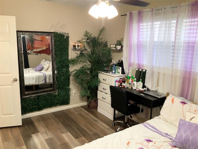 bedroom featuring baseboards, ceiling fan, and dark wood-style floors