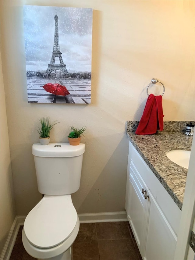 bathroom featuring vanity, baseboards, and toilet