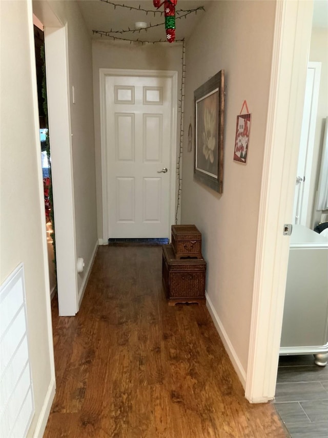 hallway featuring baseboards and wood finished floors