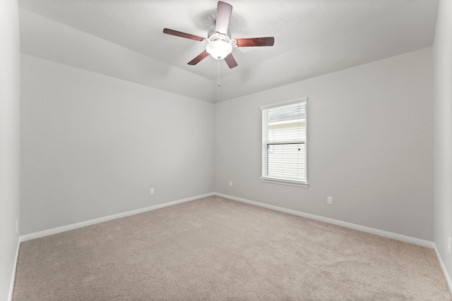carpeted empty room featuring baseboards and ceiling fan