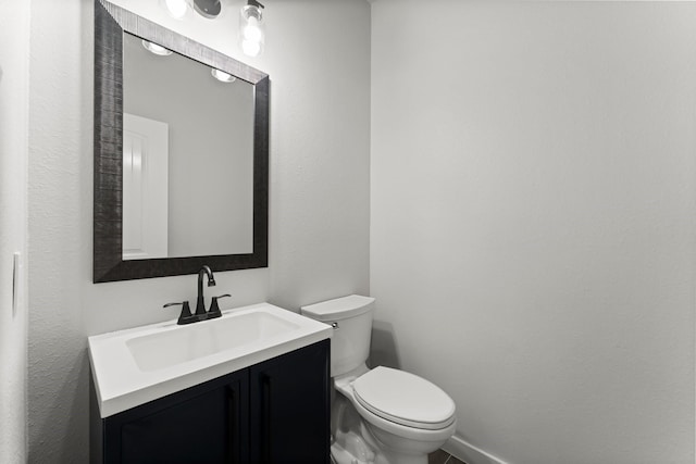 bathroom with vanity, baseboards, and toilet