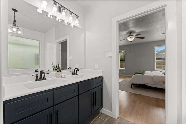full bath featuring a sink, baseboards, ceiling fan, and ensuite bathroom