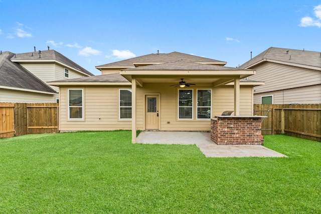 rear view of house with a ceiling fan, a fenced backyard, a yard, a patio, and a shingled roof