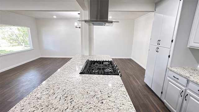 kitchen featuring cooktop, baseboards, island exhaust hood, dark wood-type flooring, and ornamental molding