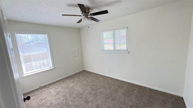 empty room with carpet floors, ceiling fan, and baseboards