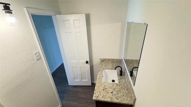 bathroom featuring vanity, baseboards, and wood finished floors