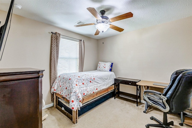 bedroom with baseboards, ceiling fan, light carpet, and a textured ceiling